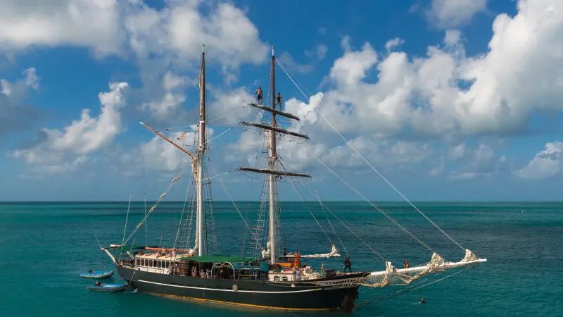 Experience the iconic Solway Lass: a majestic tall black ship cruising Whitsunday’s turquoise waters for 3 days, 2 nights under blue skies.