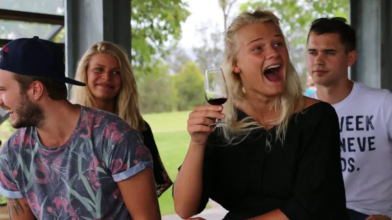 Four young adults savour red wine outdoors on a 1 Day Hunter Valley Wineries Tour from Sydney with Colourful Collective Travel.