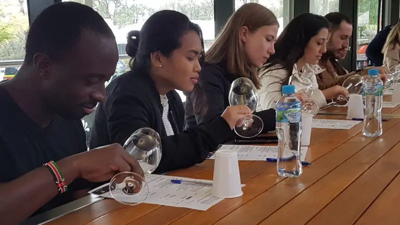 Guests on a 1 Day Hunter Valley Wineries Tour from Sydney with Colourful Collective Travel savour premium wines and review tasting notes.