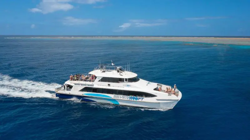 Silverswift catamaran cruises the crystal-clear blue waters on an Outer Barrier Reef snorkel and dive adventure near Cairns, Australia.