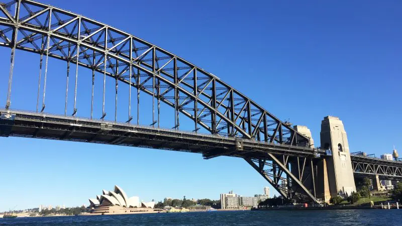 Sydney Harbour glows with the Bridge, Opera House, and skyline sparkling under clear blue skies—ideal for a top-rated Aussie Bites cruise.