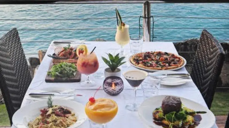 Elegant table for two with gourmet cuisine and signature cocktails at Sorrentos Restaurant, ideal for romantic Sundowner Cruise dining.