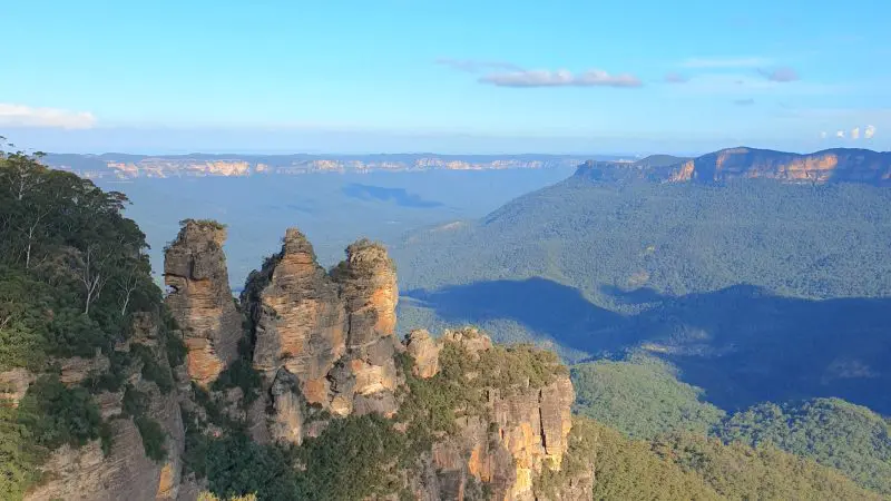 The iconic Three Sisters rock formations rise above a lush Blue Mountains valley on a guided tour with scenic waterfall walk and lunch.
