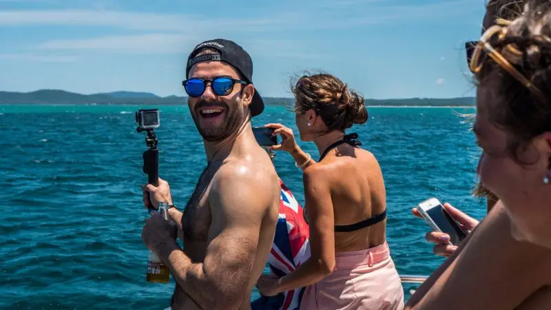 Happy group of three on a 1 Day Whale Watching Port Stephens tour with Colourful Collective Travel, enjoying scenic ocean views.