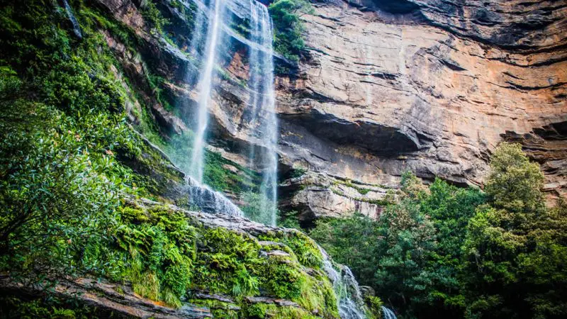 Majestic waterfall plunges beside rugged cliffs, conveniently accessible via Explorer Bus Pass Hop-On Hop-Off sightseeing service.