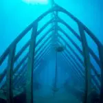 High-resolution underwater image of a boat-shaped metal sculpture on the Great Barrier Reef seen during a Townsville MOUA tour.