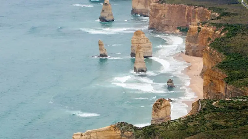 Breathtaking aerial view of the Twelve Apostles, iconic limestone stacks, ocean waves, and dramatic cliffs on Great Ocean Road tour.
