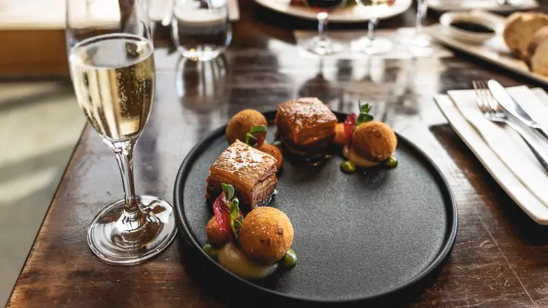 Indulge in a gourmet plated dish of crispy pork belly and champagne after your Coal River Valley Wine and Gin Safaris Private Day Tour.