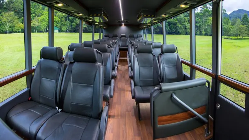 Step inside a luxurious modern tour bus with plush black leather seats, ready for your Cape Tribulation Daintree Mossman Gorge adventure.