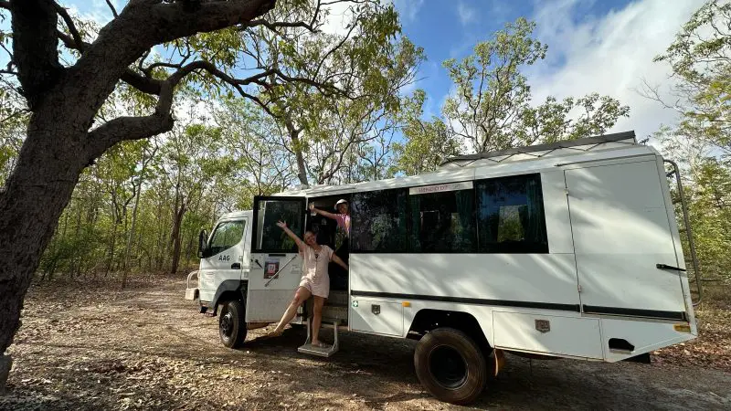 Explore adventure at Kakadu Adventure Hotel: person in doorway of rugged 4WD campervan beneath partly cloudy Northern Territory sky.