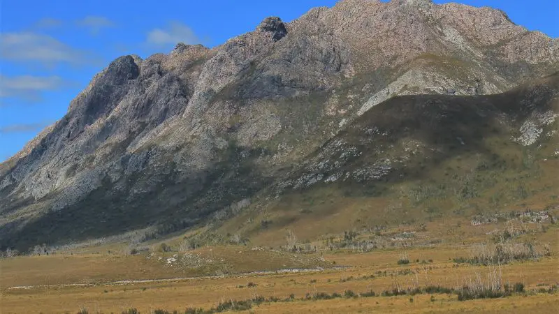 Breathtaking rocky mountain range beneath a vivid blue sky on the Gordon Dam Lake Pedder Wilderness Small Group Day Tour, Tasmania.