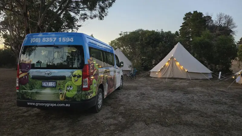 Vibrant camper van beside glowing canvas tents at dusk on a Kangaroo Island 2-Day Wildlife Adventure, perfect for nature lovers.