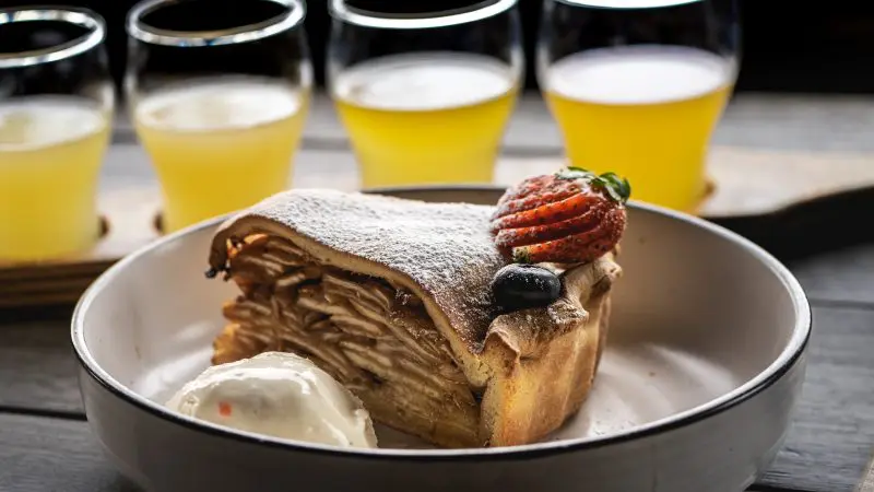 Delicious slice of apple pie topped with creamy ice cream and fresh berries, paired with drinks on Huon Valley Safaris Private Tour.