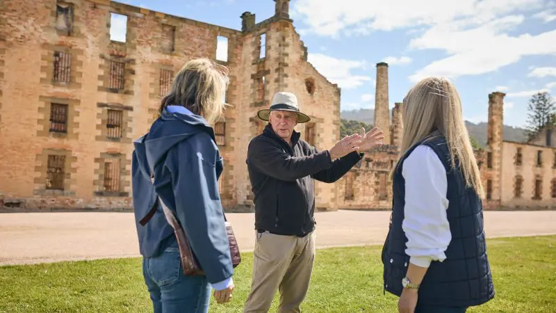 A knowledgeable tour guide engages two women with expert commentary on a Tasman Safaris Port Arthur Harbour Cruise and Lunch Tour.