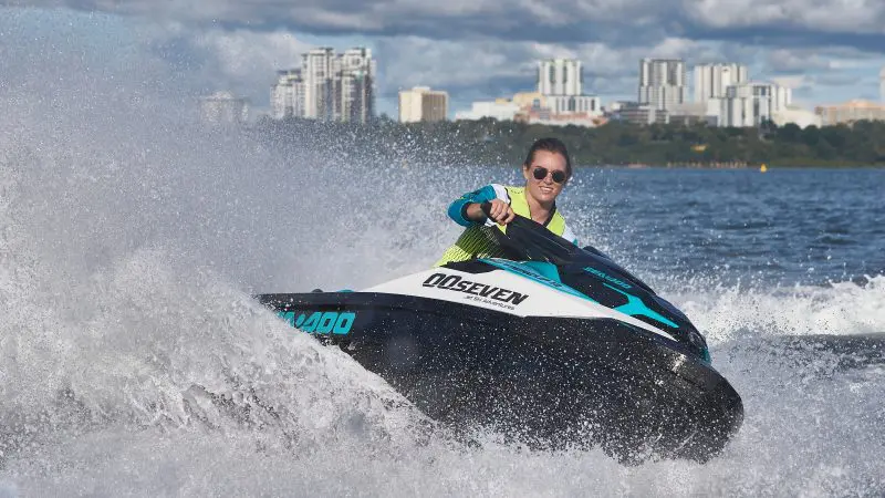 Experience the thrill of a jet ski ride at sunset on a scenic lake, city skyline in view—ideal for a top-rated Golden Eye Sunset Tour.