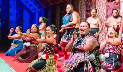 Māori performers in traditional attire dance and sing at Waitangi Treaty Grounds, showcasing authentic New Zealand cultural heritage.