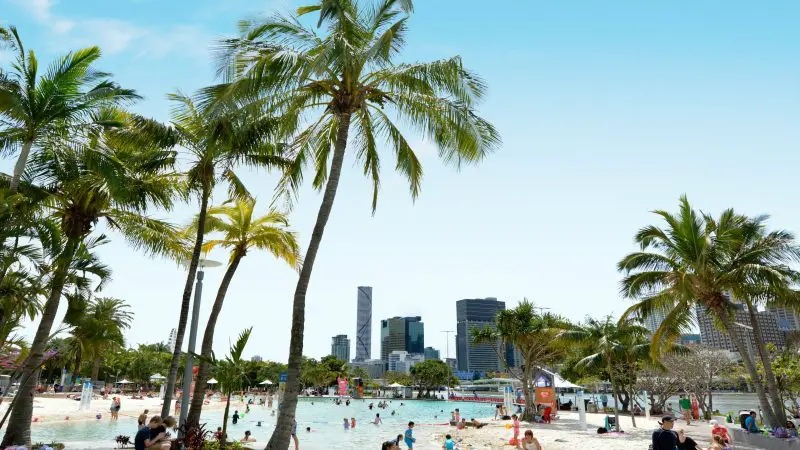 Visitors relax and have fun on a sunlit, man-made beach during The Great Escape Australia 28 Day Semi-Guided Adventure tour.
