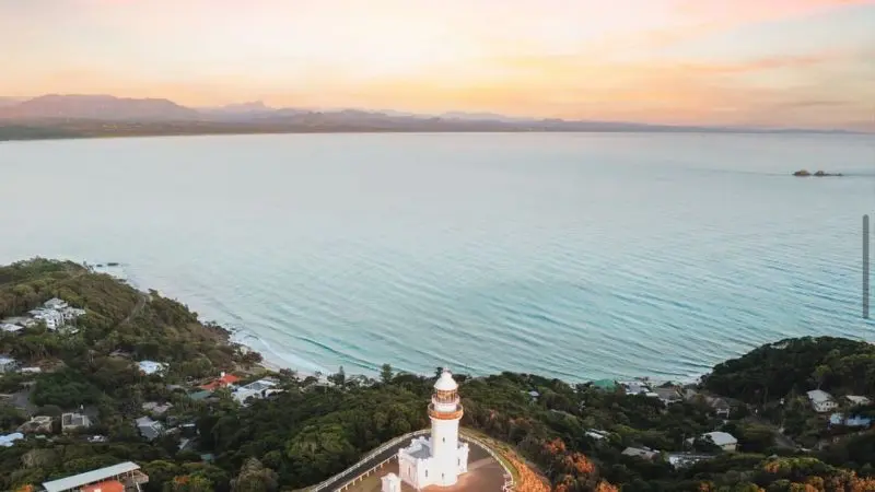 Iconic white lighthouse overlooking a scenic coastal hilltop at sunset, featured in The Great Escape Australia 28-Day Adventure Tour.
