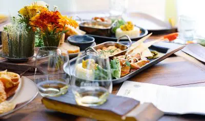 Elegant table featuring gourmet appetisers, artisan bread, fine wine glasses, and fresh flowers at a luxury boutique wine tasting tour.