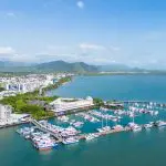 Stunning aerial view of Cairns marina with yachts, city skyline, ideal for City Sights tours or Dinner Cruise with Palm Cove Pick-up.