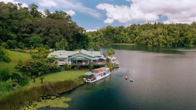 Exclusive lakeside house in Atherton Tablelands with boats, kayaks, and private tours, surrounded by lush green rainforest views.