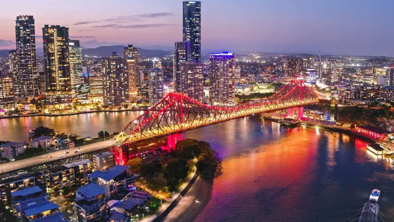 Stunning aerial view of Sydney city skyline at dusk, featuring iconic red bridge—ideal for 8 Day Sydney to Brisbane Fraser Island tour.