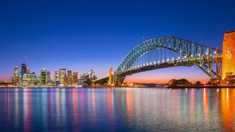Experience Sydney Harbour Bridge at dusk, city shimmering—begin your 8-Day Sydney to Brisbane and Fraser Island Comfort Tour.