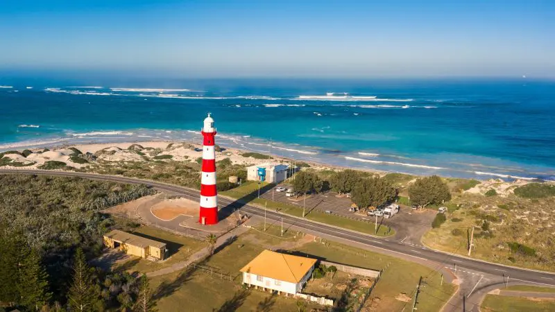 Stunning aerial view of iconic red and white striped lighthouse on the scenic 8 Day Perth to Exmouth Comfort Tour’s dramatic coastline.