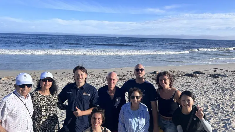 Smiling group on sandy beach during Kangaroo Island 2-Day Wildlife Adventure, enjoying unique coastal scenery and unforgettable experiences.