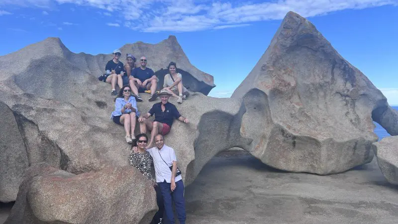 Adventurers stand atop iconic, sculpted granite boulders beneath a vibrant blue sky on Kangaroo Island’s renowned 2 Day Tour.