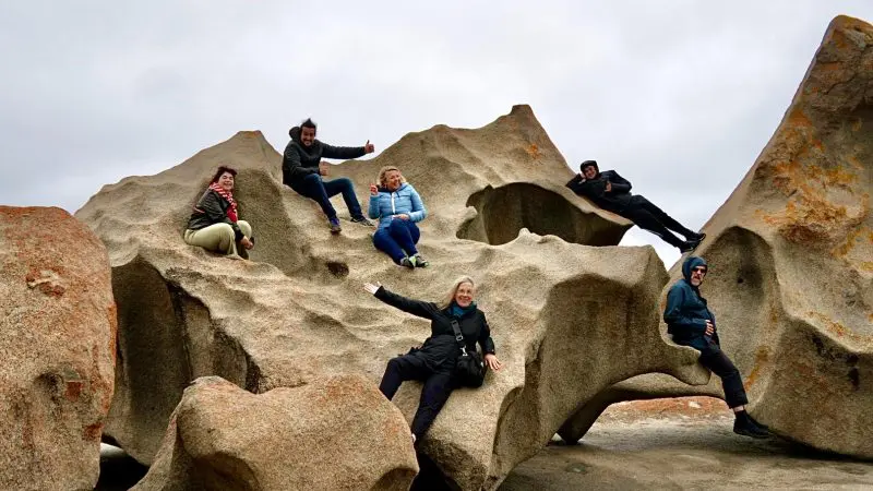 Six adventurers explore dramatic Kangaroo Island rock formations beneath a moody sky on their unforgettable 2-day wildlife tour experience.