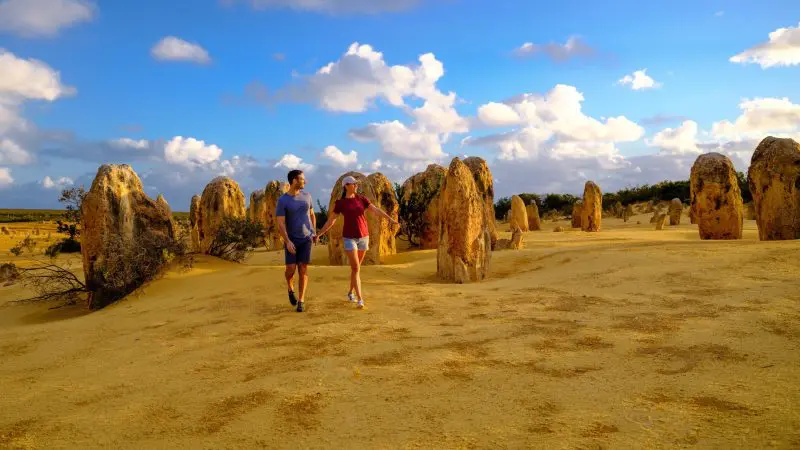 A couple explores the Pinnacles Desert's unique limestone formations during a 1 Day Sunset Stargazing Tour with Autopia Tours.