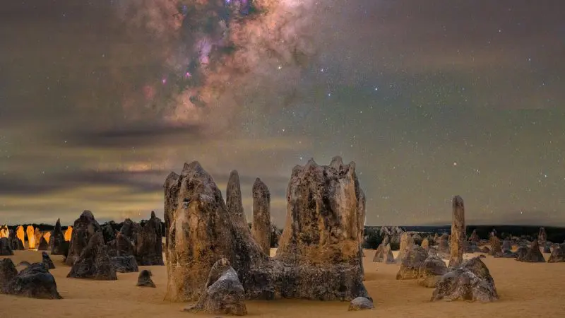 Dramatic limestone pinnacles rise from golden desert sands under a stunning Milky Way sky on the Autopia 1 Day Sunset Stargazing Tour.