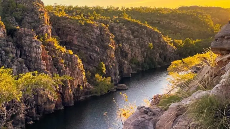 Experience a breathtaking Katherine Gorge cruise from Darwin at sunset, where a scenic river winds through rocky cliffs and lush greenery.
