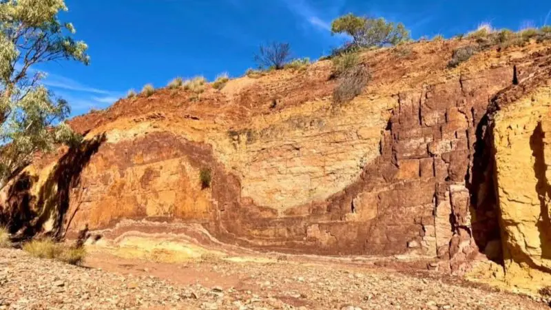 Scenic rocky outcrop with scattered native vegetation along the 1 Day West MacDonnell Ranges and Standley Chasm tour trail.