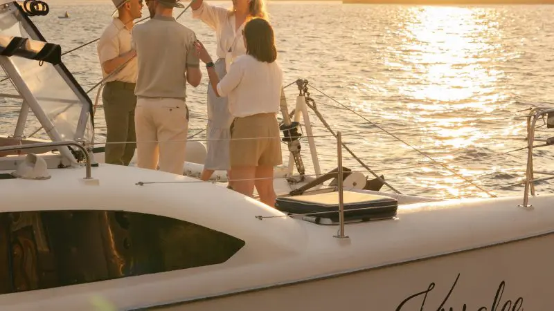 Group of friends toasting drinks at sunset on Kirralee catamaran cruise, Sydney Harbour, BYO Sparkle tour, stunning city views.