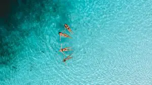 A group of friends floating in the clear waters of Lake Mckenzie