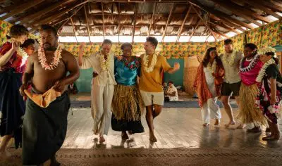 Image of travellers dancing with locals in Fiji during their village tour to experience local cultures and ceremonies