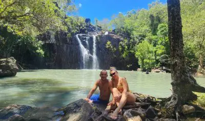 Picture of a couple sitting in front of Cedar Falls close to Airlie Beach in Australia