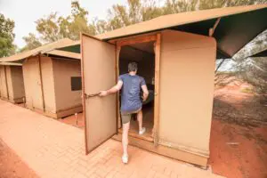 Image of man entering Safari Tent at the Campsite during an overnight Uluru Outback adventure