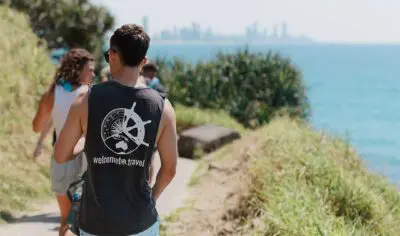 a group of people walking along a path on a cliff edge