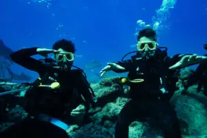 Image of two scuba divers, diving in the ocean with sharks in Fiji