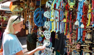 A woman looking at jewellery at a market stall.