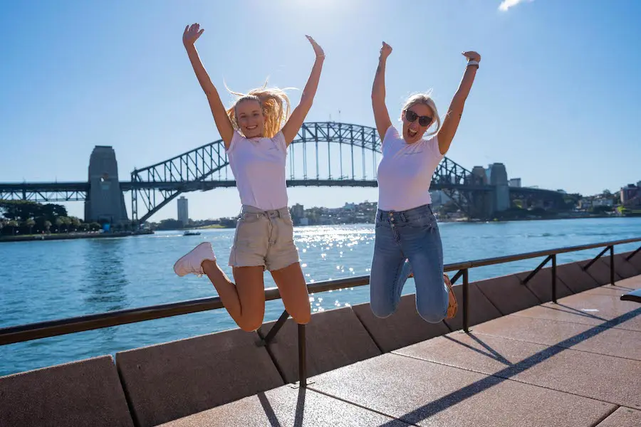 girls jumping in front of sydney harbour bridge australia