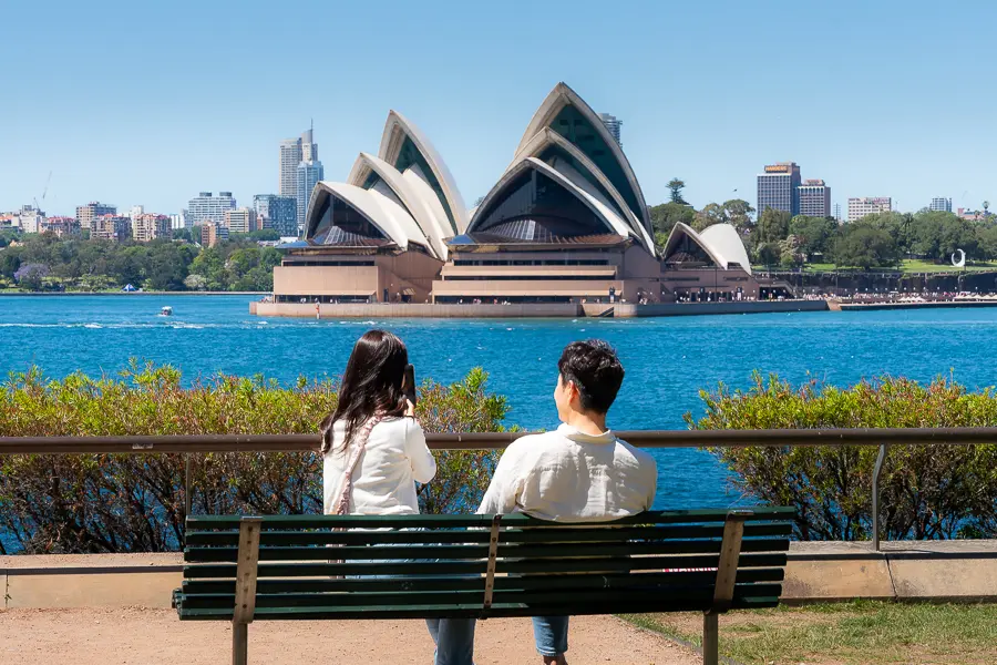 people on a bench near sydney opera house