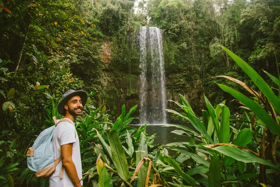man with backpack near millaa millaa falls cairns