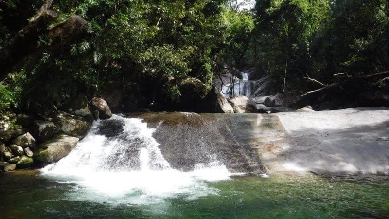 Experience the serene beauty of a cascading waterfall over smooth rocks into a crystal-clear pool on the 1 Day Waterfall Wanderers Tour.