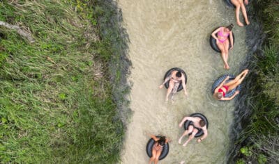 a group of friends having fun with inflatable tubes on a river