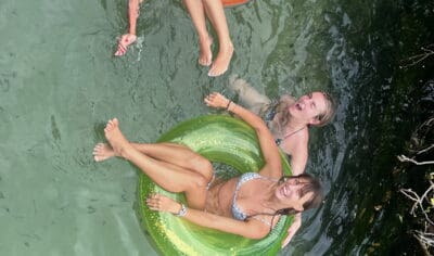 a group of friends having fun with inflatable tubes on Eli Creek River