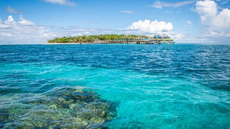 Stunning turquoise waters, vibrant coral reefs, and a boat await near lush Green Island—ideal for a 1pm Half Day Green Island tour.